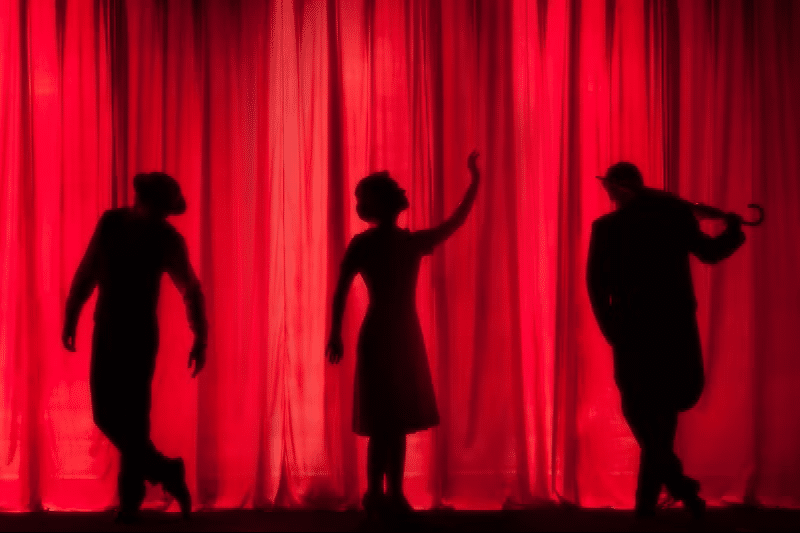 "Noite no Teatro" Imagem de silhuetas de pessoas no palco